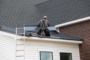 Person examining bruised roof shingles and granules collected in a gutter after a hailstorm.
