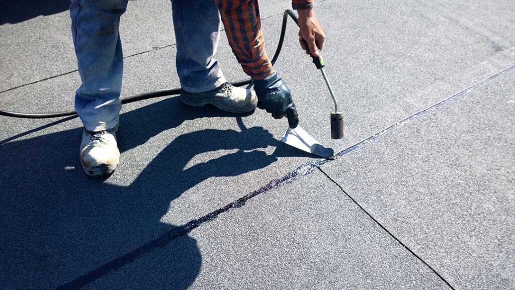 Metal flashing protects the joint between shingles and a chimney on a residential roof.